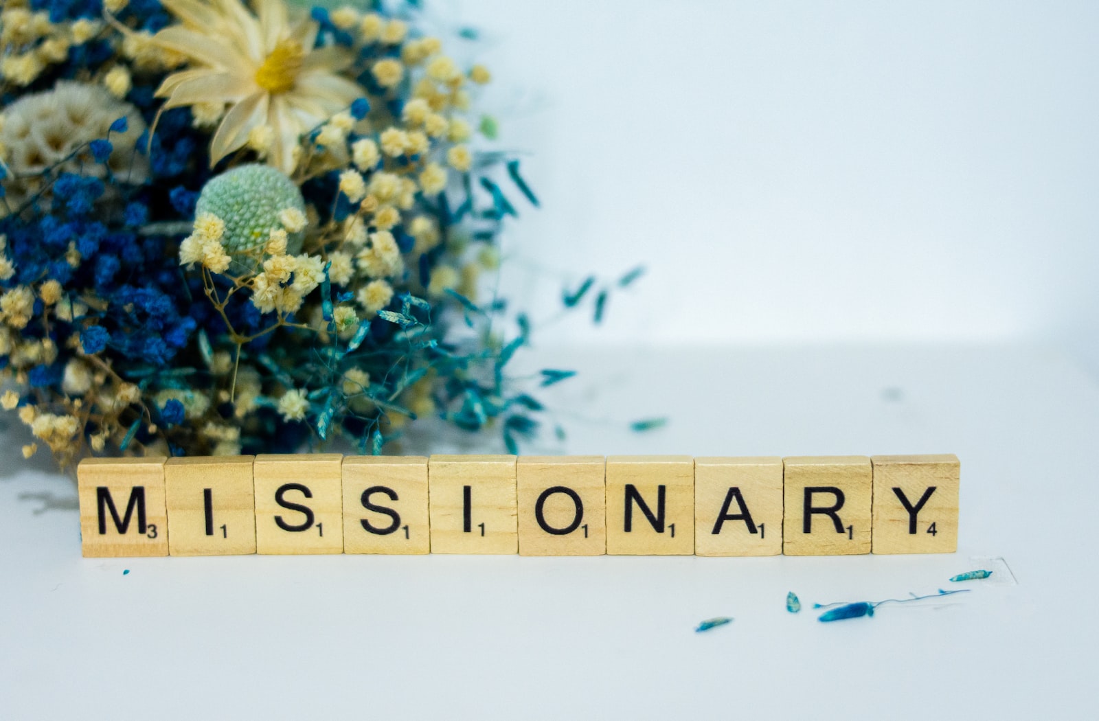 a wooden block that says,'missionary'next to a bouquet of flowers